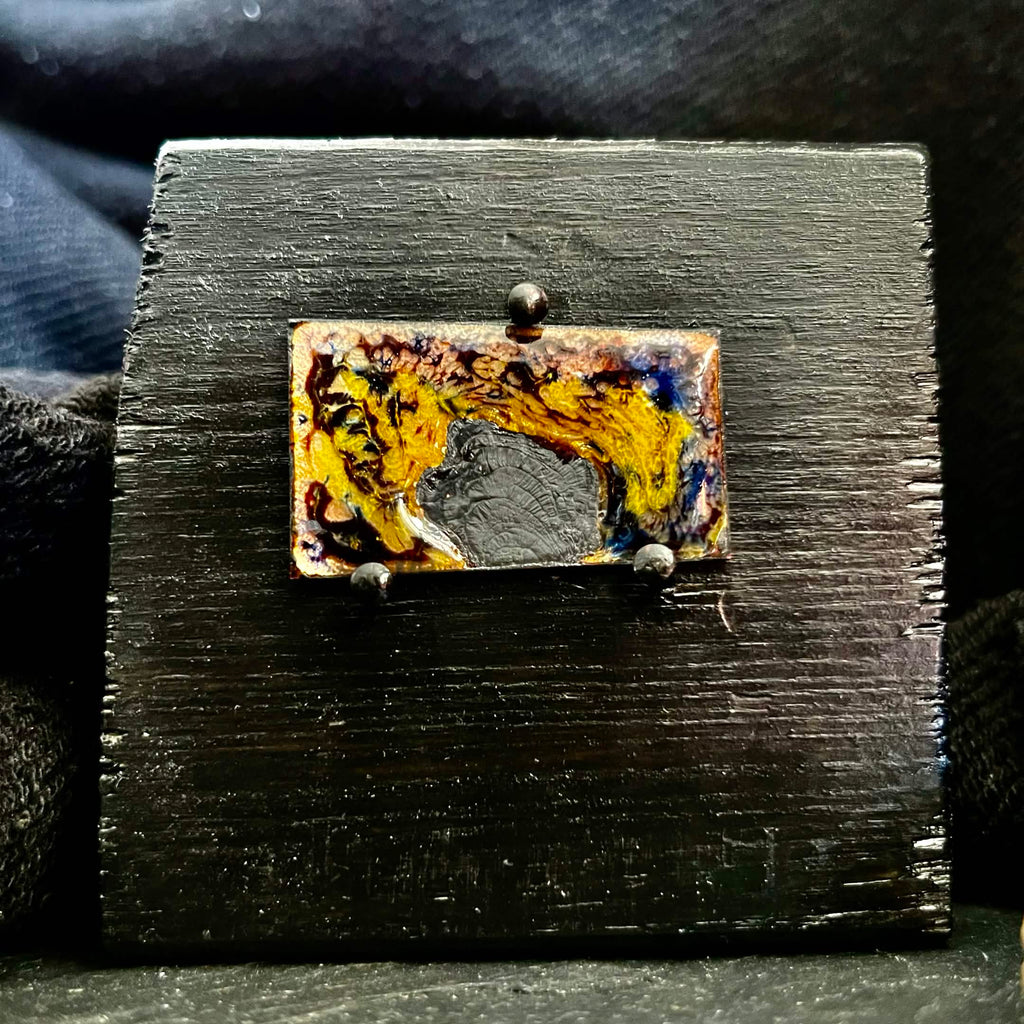 Fly Nest – original cloisonné enamel miniature on copper mounted on a black wooden frame, front view. Swirling brown, gold and blue enamel fired in the kiln. Handcrafted by A. Fraction.