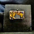 Fly Nest – original cloisonné enamel miniature on copper mounted on a black wooden frame, front view. Swirling brown, gold and blue enamel fired in the kiln. Handcrafted by A. Fraction.
