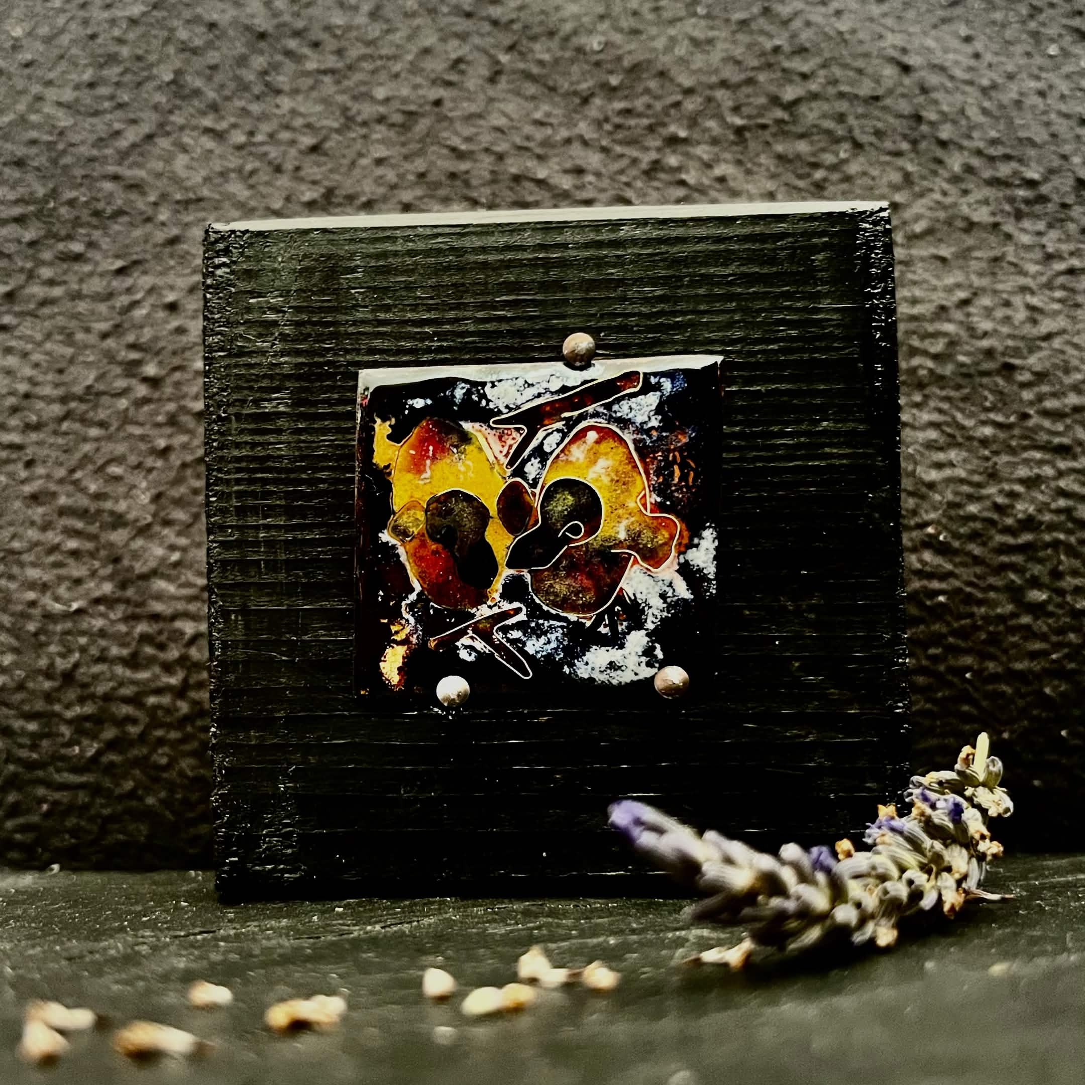 Baby Pigeons — vitreous enamel on copper miniature, 40 × 36 mm, fine silver cloisonné, kiln-fired. Warm amber, red and dark tones depicting two baby pigeons in a nest. Displayed on handmade black pine stand, 80 × 80 mm. House Zoo series by A. Fraction, Vilnius.