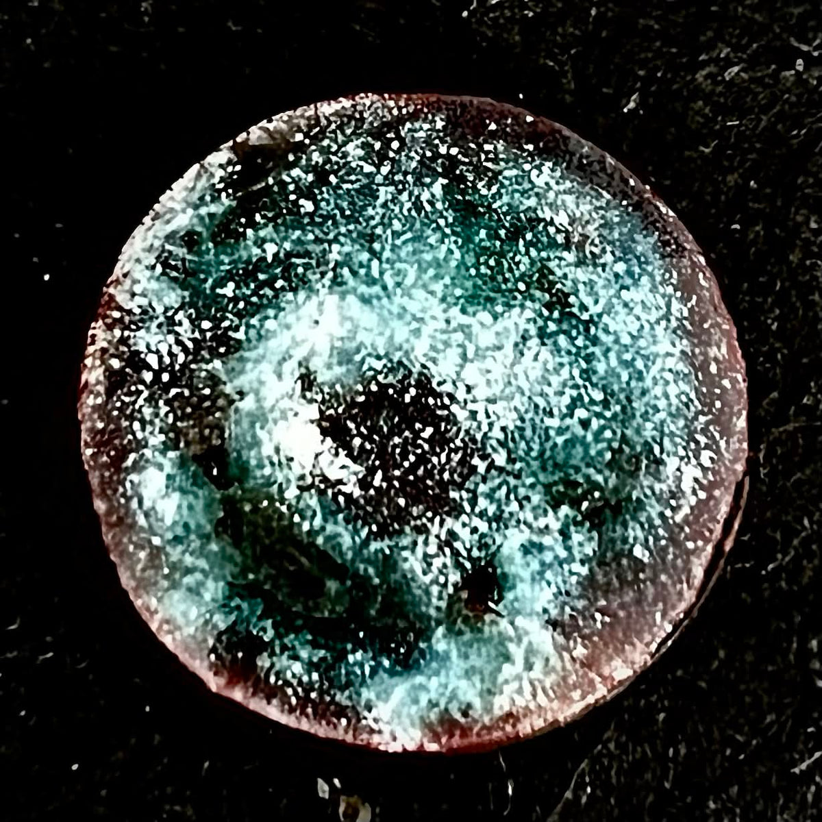 Magnetic Storm – original wet-packed vitreous enamel miniature on a round copper disc, front view on dark slate. Turquoise and white enamel with a stormy speckled texture and warm copper-red rim. Original one-of-a-kind piece by A. Fraction.