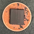 Magnetic Storm – reverse side of the round copper miniature on dark slate, showing the raw copper back with upcycled black rubber magnet mounted at the centre. Original one-of-a-kind piece by A. Fraction.