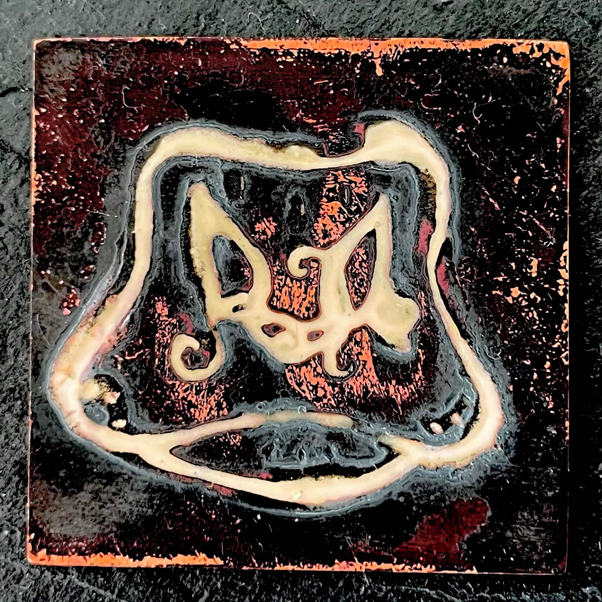Cow's Hairy Nose - champlevé enamel on copper, cream-coloured recessed lines forming a surrealist cow nose with curling hairs on a deep dark fired oxidised copper, by A. Fraction